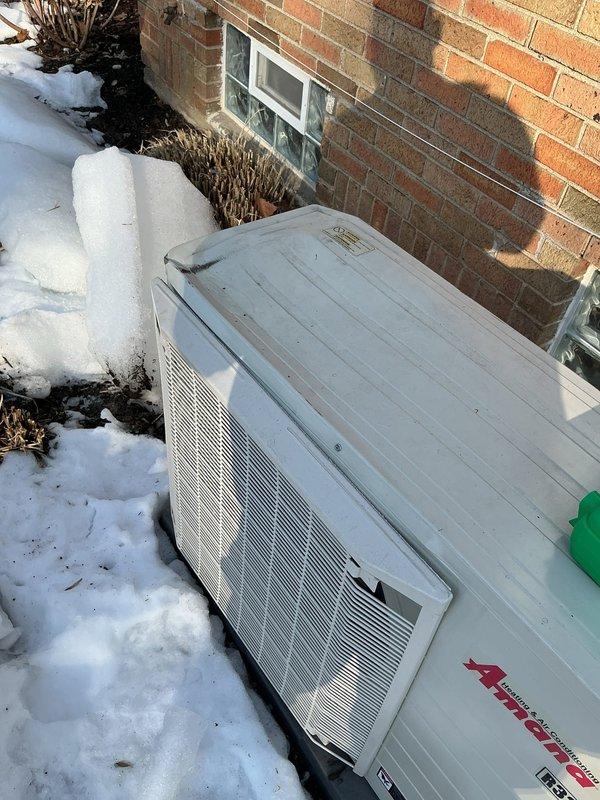 Inspected 6-month-old EnergiAir WT 03-2035 unit reportedly damaged by falling ice. Found visible corrosion at mounting bracket and unit base, with significant snow and ice accumulation against the condenser. Confirmed heating function operational; cooling function could not be tested due to winter conditions.