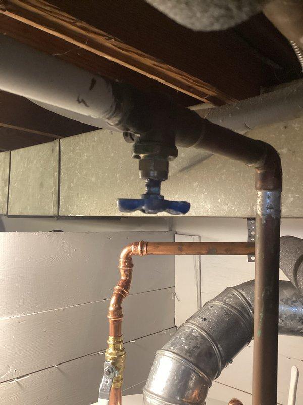 Relocated incorrectly installed cold water valve that was causing a leak in the basement plumbing system. Properly repositioned and secured the blue shut-off valve on the black pipe fittings above the copper supply lines, ensuring all connections were sealed and tested for proper function with the Bradford White water heater system.