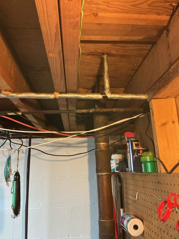 Inspected and repaired leaking plumbing system in basement utility area. Identified water damage on wooden backboard under sink cabinet with multiple connection points showing signs of previous leakage. Replaced damaged P-trap assembly and secured loose connections in the PVC drain pipe configuration, resolving the active leak and preventing further water damage to surrounding structures.