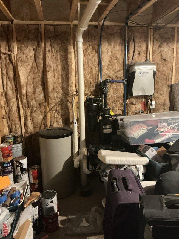 Diagnosed 6-year-old water heater with active leak at tank body, indicating tank failure. Recommended complete replacement as repair is not feasible for this type of internal corrosion issue. Documented condition with photos showing installation location in utility space with exposed insulation and surrounding plumbing connections.