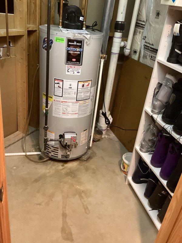 Diagnosed 9-year-old water heater with active leak at tank base and no hot water output. Customer had correctly shut off water supply and power to unit prior to arrival. Confirmed tank failure requiring full replacement due to age and deterioration visible at bottom of tank.