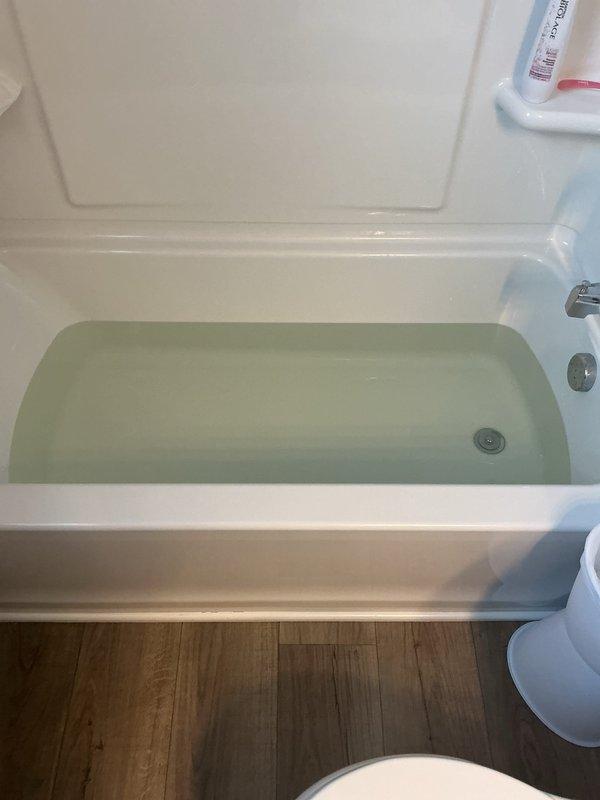 Performed diagnostic flush on 2-month-old Lochinvar water heater experiencing discolored water with sediment after installation of electric anode rod. Observed yellowish-gray water discharge during flush procedure, indicating mineral buildup. Recommended reverting to original anode rod configuration to address water quality issues, as the aftermarket electric anode appears incompatible with this system.