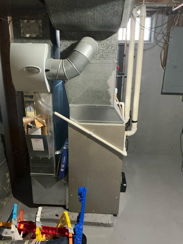 Responded to service call for a leaking 15-year-old Bryant furnace. Upon inspection, identified significant corrosion around heat exchanger and secondary heat exchanger with visible water leakage. System has Aprilaire humidifier mounted to side with standard PVC venting. Recommended full replacement due to age of unit and extent of damage, as repairs would not be cost-effective. Provided customer with replacement options and took detailed photos for documentation.