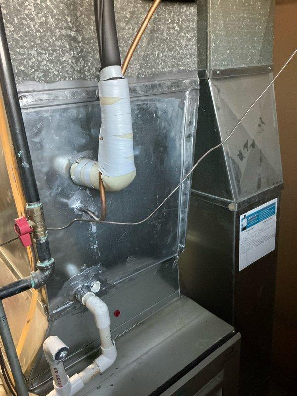 Responded to service call for a leaking 15-year-old Bryant furnace. Upon inspection, identified significant corrosion around heat exchanger and secondary heat exchanger with visible water leakage. System has Aprilaire humidifier mounted to side with standard PVC venting. Recommended full replacement due to age of unit and extent of damage, as repairs would not be cost-effective. Provided customer with replacement options and took detailed photos for documentation.