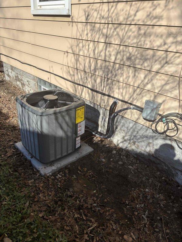Successfully installed and replaced a residential air conditioning system including an outdoor condenser unit mounted on a concrete pad with proper line set connection and electrical disconnect box. The indoor portion of the installation included connecting the new cooling unit to the existing Gibson furnace with appropriate PVC ventilation/drainage piping and flexible ductwork in the utility area.