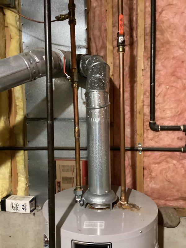 Responded to service call for leaking water heater. Upon inspection of the 16-year-old Bradford unit, found significant corrosion at the tank connection point with visible mineral deposits. Replaced the aging water heater with a new unit, ensuring proper installation of all supply lines, drain connections, and vent piping.