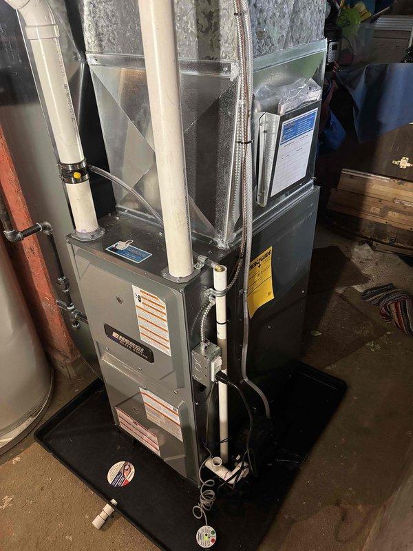 Successfully completed installation of new residential furnace unit with PVC ventilation system. Connected all required ductwork, including proper venting configuration, and positioned unit on protective drip pan in basement mechanical room. System was fully tested and verified operational alongside existing water heater.