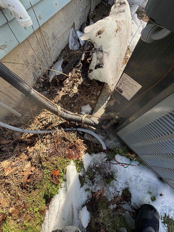 Responded to customer report of non-cooling air conditioner after liquid spill on approximately 1-1.5 year old EnergiAir unit. Inspection revealed significant debris accumulation at exterior unit location with improper drainage, causing moisture ingress. Documented exterior condition including inadequate sealing where refrigerant lines enter building. Provided customer with assessment of damage and repair options.