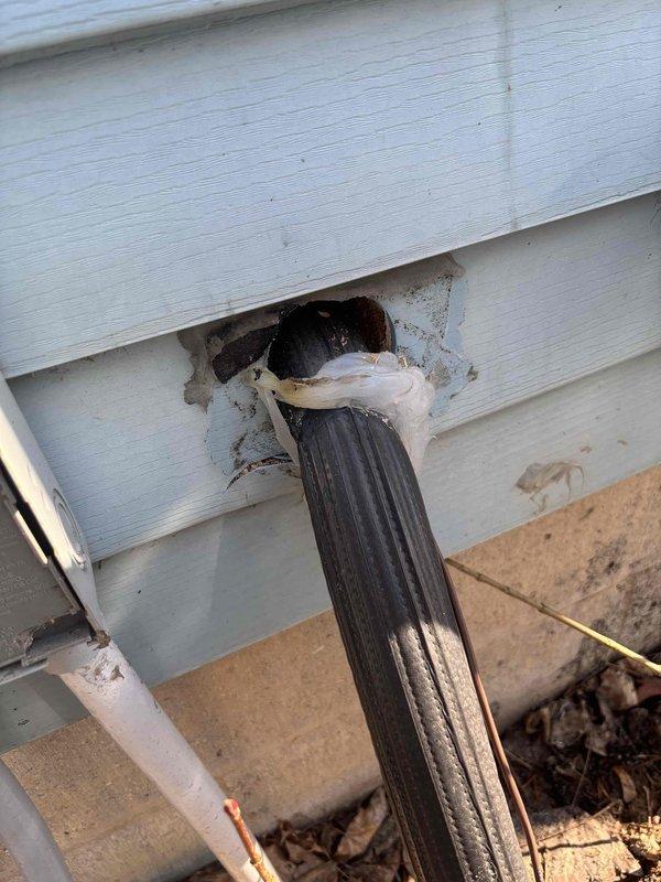 Responded to customer report of non-cooling air conditioner after liquid spill on approximately 1-1.5 year old EnergiAir unit. Inspection revealed significant debris accumulation at exterior unit location with improper drainage, causing moisture ingress. Documented exterior condition including inadequate sealing where refrigerant lines enter building. Provided customer with assessment of damage and repair options.