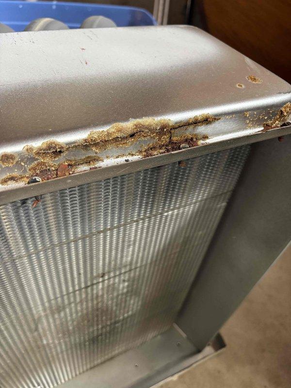 Replaced heavily corroded heat exchanger (HTX) unit that exhibited significant rust damage along the metal housing and seams. Documented pre-replacement condition with photos showing extensive oxidation on the metal frame while the internal coil structure remained functional.