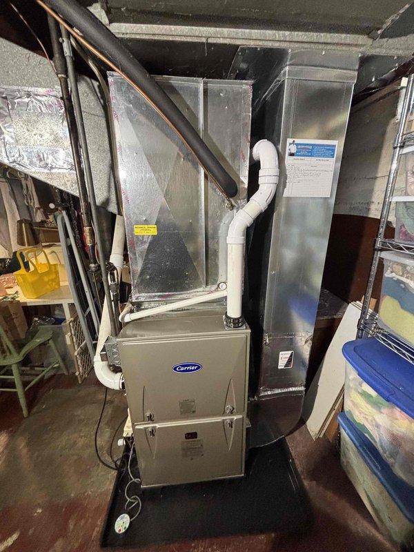 Successfully installed a new Carrier furnace system in basement utility area, including proper connection of all ductwork, PVC ventilation piping, and electrical components. Unit was mounted on a platform with condensate drain lines properly routed and all manufacturer specifications verified for optimal system performance.