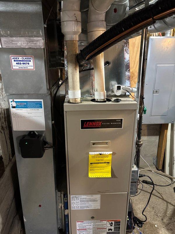 Successfully installed new Lennox Elite Series HVAC system including outdoor condensing unit on concrete pad with proper connections to the home. Complete installation included indoor furnace unit with PVC venting and ADEX-CLASSIC component, all properly connected to electrical panel and ductwork in utility area.