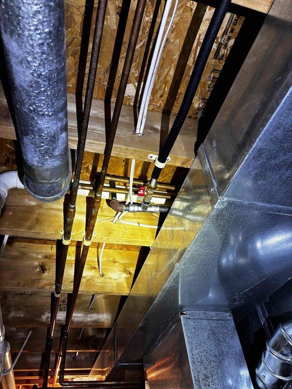 Completed installation of a new gas line for customer's stove, including a new shut-off valve and appliance connector. Work involved routing yellow flexible gas line with appropriate fittings and installing a red shut-off valve where the line connects to the wall fixture. Accessed ceiling joists to properly connect to existing gas supply infrastructure, ensuring secure connections and proper installation according to code requirements.