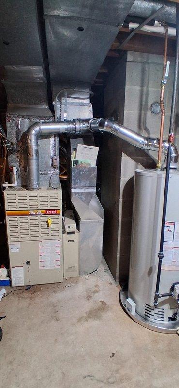 Successfully installed new water heater in basement location, replacing existing unit. Connected copper supply lines and properly vented system through existing chimney using required 4" B-vent components to bring installation up to current code requirements.