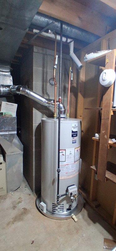 Successfully installed new water heater in basement location, replacing existing unit. Connected copper supply lines and properly vented system through existing chimney using required 4" B-vent components to bring installation up to current code requirements.