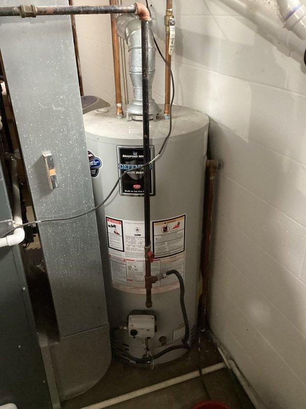 Performed annual heating system maintenance on a 15-year-old furnace. Inspected heat exchanger and coils which showed normal wear. Noted water heater installation in utility area with proper connections and ventilation. System functioning properly after service.