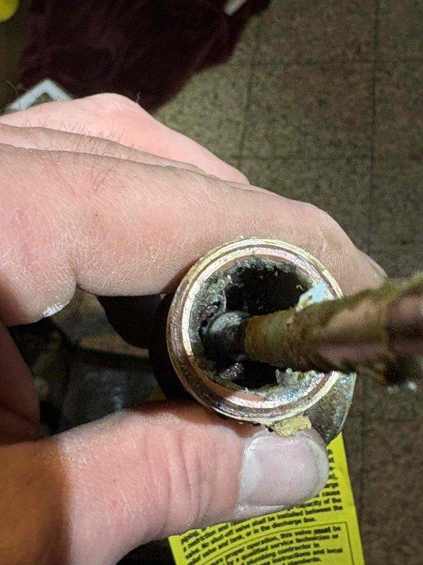 Diagnosed and repaired water heater leak originating from pressure relief valve discharge tube. Replaced corroded brass fitting and discharge pipe to restore proper drainage functionality and prevent further leaking.