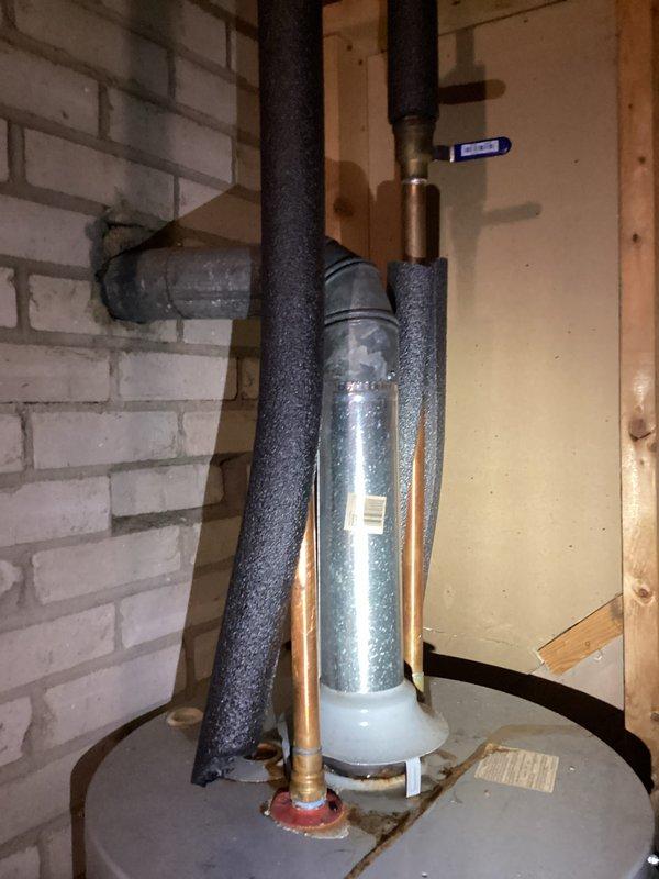 Conducted assessment of 16-year-old water heater that failed to operate. Diagnosed multiple issues including pilot light failure and evidence of leakage into catch basin. After thorough inspection of gas valve assembly, tankless components, and ventilation system through brick wall, determined unit requires replacement due to age and deteriorating condition.