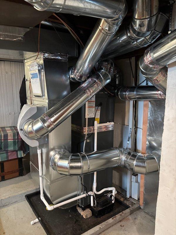 Successfully completed add-on air conditioning installation with new furnace/air handler unit in basement. Installed complete metal ductwork system with proper sealing at all junction points. Established exterior electrical connections with junction box mounted to vinyl siding, including all necessary conduit and wiring.