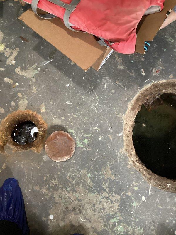 Responded to basement flooding complaint occurring during heavy rain and household water usage. Inspected concrete floor drain system, finding significant water poolback and pooling around main floor drain. Performed drain augering service with snake to clear blockage in century-old drainage pipes, successfully restoring proper water flow and eliminating basement flooding issue.