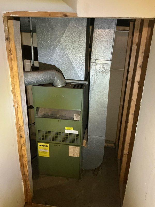 Conducted inspection of 1980s natural gas forced air furnace system located in basement. Documented existing Rheem unit with associated ductwork in unfinished utility space. Customer seeking complete system removal, potential re-ducting, water heater upgrade (currently 10 years old), and consultation for heat pump system installation as part of planned home renovations.