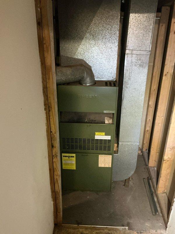 Conducted inspection of 1980s natural gas forced air furnace system located in basement. Documented existing Rheem unit with associated ductwork in unfinished utility space. Customer seeking complete system removal, potential re-ducting, water heater upgrade (currently 10 years old), and consultation for heat pump system installation as part of planned home renovations.