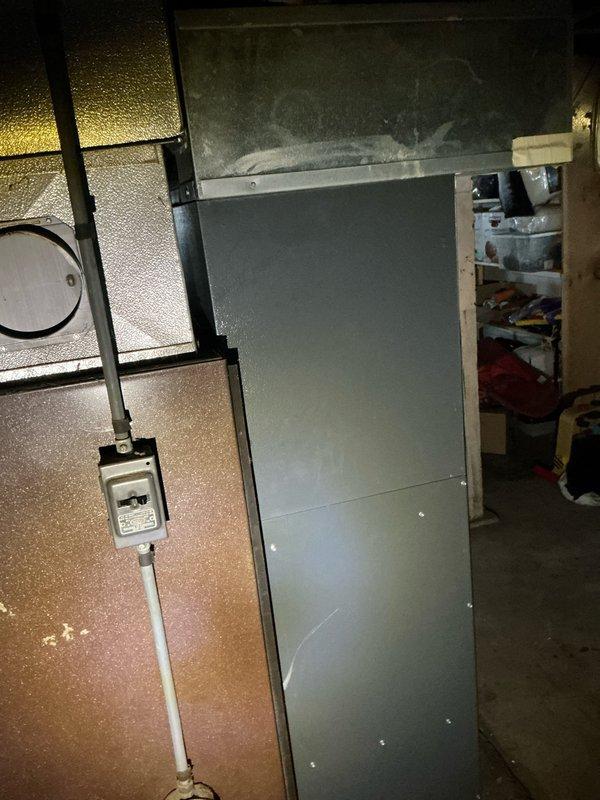 Conducted comprehensive estimate for replacement of 16-year-old AC system. Inspected both the indoor air handler located in basement utility room and outdoor condensing unit positioned within fenced enclosure adjacent to house. Documented current system condition with photographs for assessment purposes.