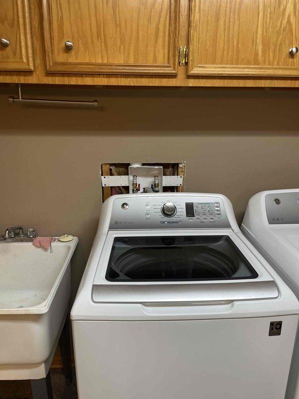 Completed QUOTR repair by raising laundry box to proper height for customer's washing machine connections. Installed new hammer arrestors on both hot and cold water supply lines and ensured proper connection of flexible supply lines and drainage hose. Total service time: 2.5 hours.