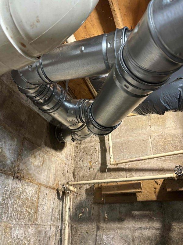 Successfully installed a new Bradford White water heater in the basement utility area, including all necessary copper pipe connections and metal vent piping. Unit was properly secured against the concrete block wall with all manufacturer specifications followed for safe operation.