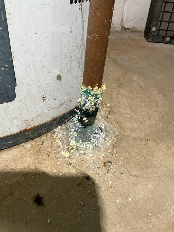 Performed annual heating maintenance on 15-year-old GDM furnace. Observed significant copper pipe corrosion at water heater connection point with mineral buildup spreading onto concrete floor. Documented Richmond water heater condition with visible warning tags and connection issues for future reference.