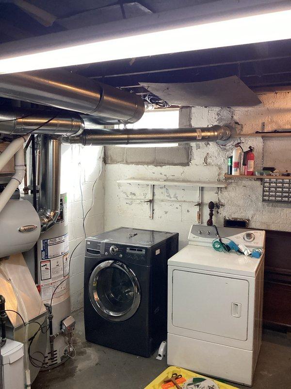 Conducted water heater estimate in basement utility room where existing unit shows significant corrosion and rust on copper supply pipes and connection points. Documented current installation configuration including ventilation system, shutoff valves, and surrounding utility infrastructure for replacement recommendation.
