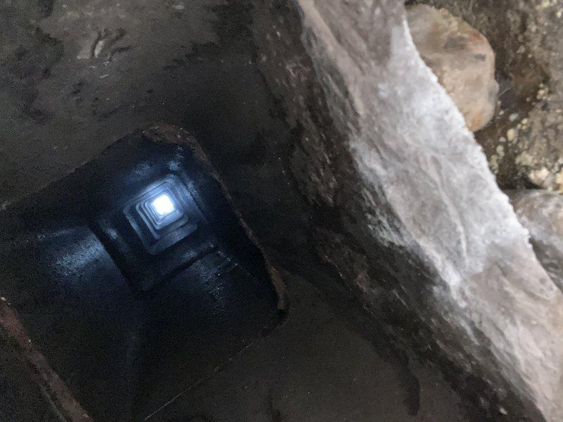 Successfully installed a chimney liner system through a challenging access point. The installation required navigating through a narrow passageway with moisture concerns, and properly sealed the metal liner where it penetrates the concrete wall using appropriate fire stop collars.
