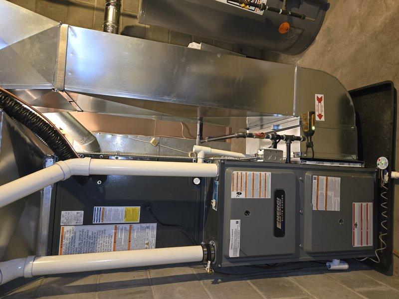 Successfully completed installation of a new MRCOOL central air conditioning system and furnace unit. The outdoor AC condenser was properly mounted on a concrete pad with wooden platform over decorative gravel, while the indoor furnace was installed with appropriate ductwork connections and PVC drainage/ventilation piping. Both units were tested and confirmed to be functioning according to manufacturer specifications.