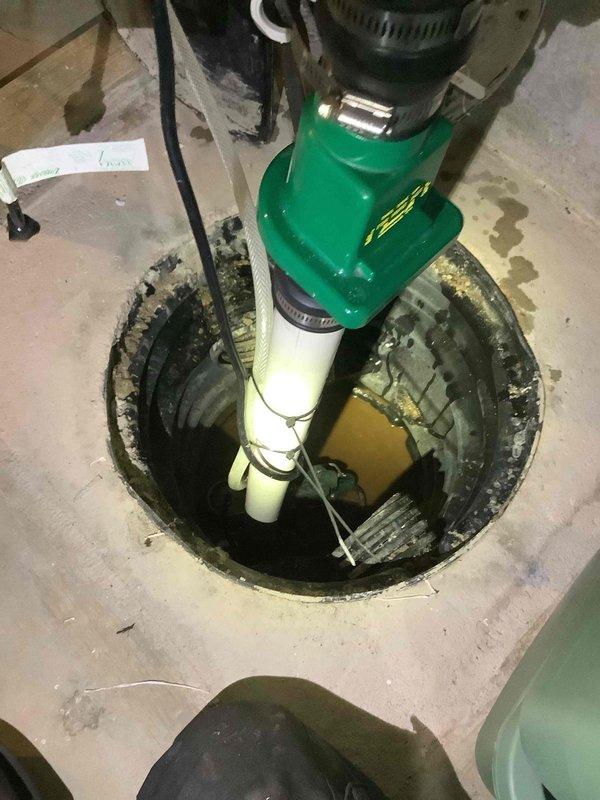 Replaced failed 25-year-old sump pump with new green submersible unit in basement sump pit. Installed pump with proper PVC discharge piping and verified float switch operation. System is now functioning correctly with appropriate water evacuation to prevent basement flooding.