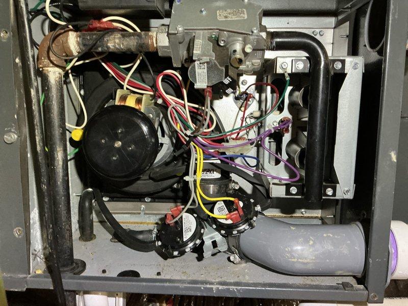 Responded to no-heat call for system previously serviced for drainage issues. Upon inspection of the furnace, identified failed pressure switch causing system lockout. Cleaned condensate drain line and reset system, restoring proper operation. Verified all connections and documented condition with photos of internal components and drainage system.