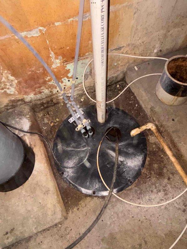 Completed installation of a comprehensive water treatment system in basement utility room, including multiple filtration tanks (one green, two gray with digital control panels) with all necessary copper and PVC piping connections. Additionally, installed sump pump system with basin embedded in concrete floor and proper discharge piping to prevent basement flooding.