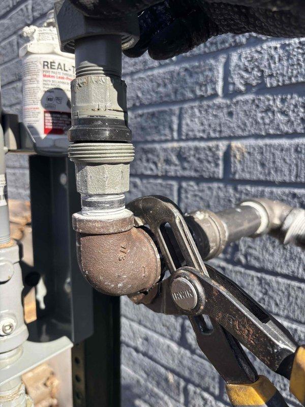 Successfully completed CONV-LP to NG conversion with no complications. Accessed property through unlocked door while unoccupied and documented installation with photos showing the exterior connection point and the updated plumbing components attached to the structure.