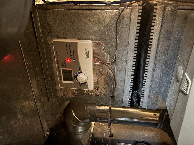 Performed comprehensive furnace tune-up and serviced Aprilaire humidifier as requested under 4-year Energy Enhancement program. Inspected and tested electronic control unit, which showed proper operation with illuminated indicator light. Examined heat exchanger elements, ductwork connections, and system mounting, verifying all components were functioning correctly and properly secured.