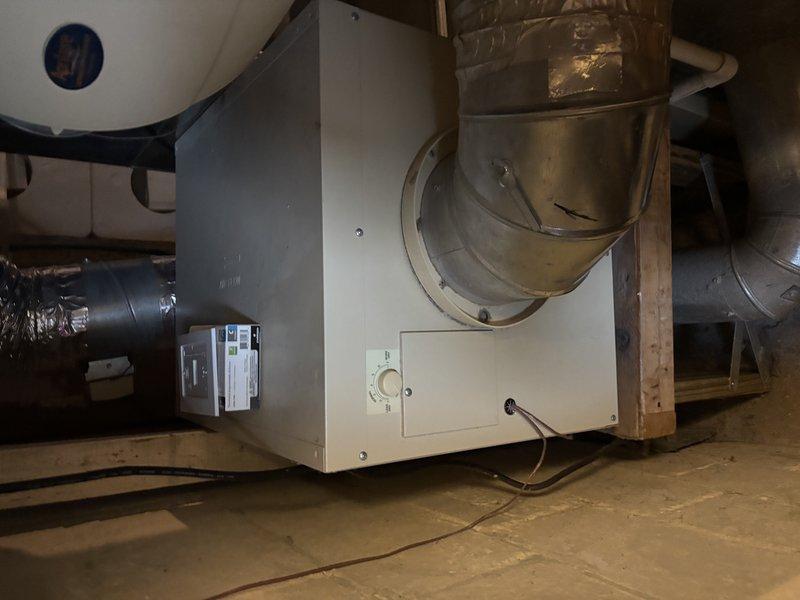 Performed comprehensive furnace tune-up and serviced Aprilaire humidifier as requested under 4-year Energy Enhancement program. Inspected and tested electronic control unit, which showed proper operation with illuminated indicator light. Examined heat exchanger elements, ductwork connections, and system mounting, verifying all components were functioning correctly and properly secured.