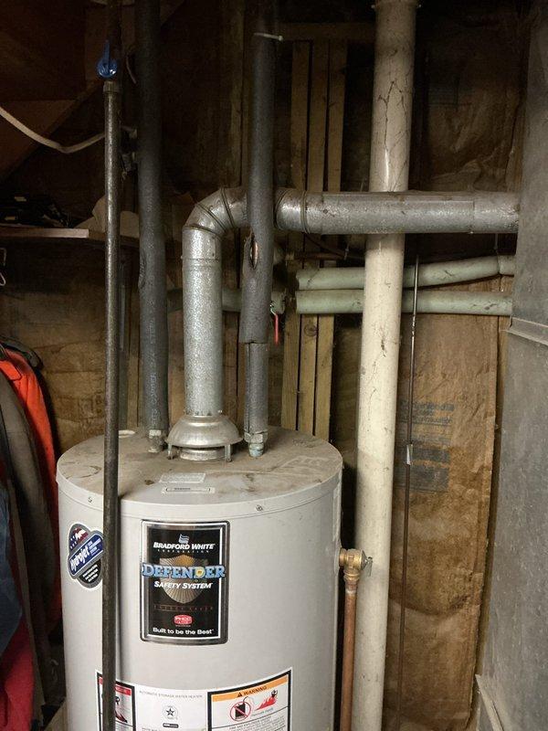 Diagnosed Bradford White water heater with active leak at bottom of tank, indicating tank failure. Documented condition with photos showing the installation environment and unit specifications. Advised customer that complete replacement is required as tank leaks are not repairable.