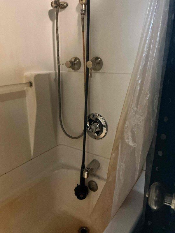 Returned to property to complete a scheduled shower valve replacement as per QUOTR. Accessed plumbing through wall cavity, removed existing valve assembly, and installed new shower valve with proper copper pipe connections and brass fittings. Successfully completed installation of new shower fixtures including dual shower head system with handheld attachments, tested for proper function and leaks, and restored service to the bathroom shower/tub combination unit.