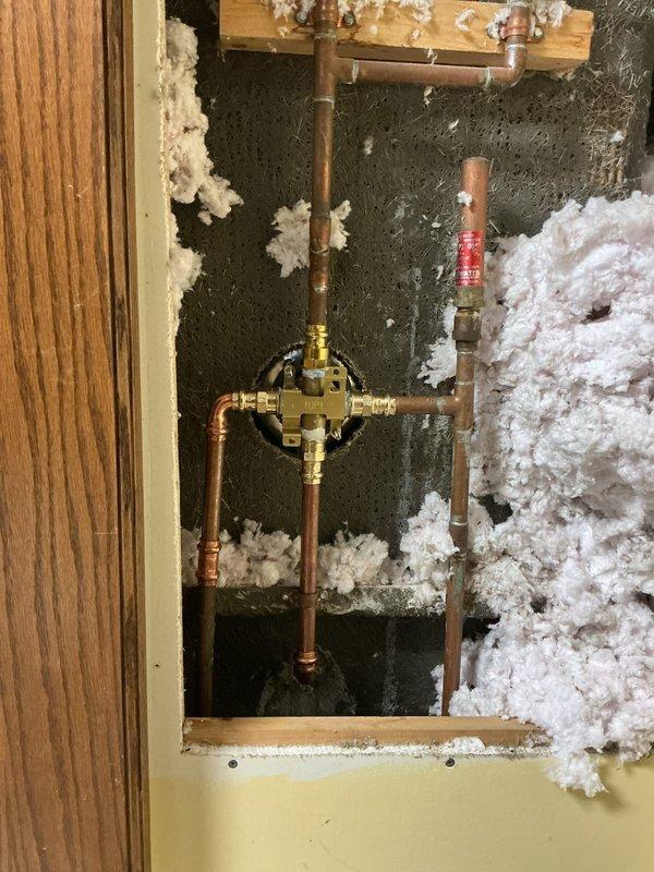 Returned to property to complete a scheduled shower valve replacement as per QUOTR. Accessed plumbing through wall cavity, removed existing valve assembly, and installed new shower valve with proper copper pipe connections and brass fittings. Successfully completed installation of new shower fixtures including dual shower head system with handheld attachments, tested for proper function and leaks, and restored service to the bathroom shower/tub combination unit.