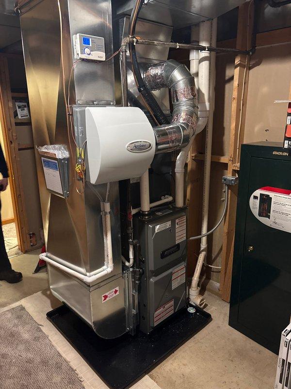 Successfully completed installation of a new furnace system and outdoor AC condenser unit. The furnace installation included an Aprilaire humidifier with proper ductwork connections in the basement utility area, while the outdoor unit was properly mounted on a concrete pad with electrical connections secured to the exterior wall.