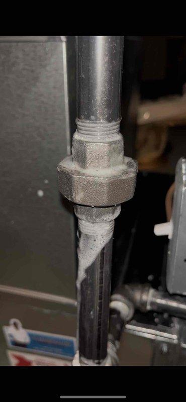 Responded to inspector correction regarding gas leak at union fitting in basement. Located and repaired leaking connection at hexagonal union fitting on gas line. Performed soap bubble test to verify leak elimination and documented repair with photographic evidence for inspector verification.