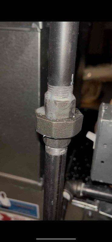 Responded to inspector correction regarding gas leak at union fitting in basement. Located and repaired leaking connection at hexagonal union fitting on gas line. Performed soap bubble test to verify leak elimination and documented repair with photographic evidence for inspector verification.