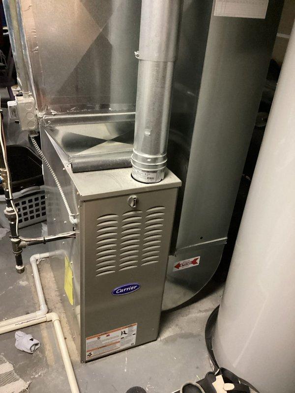 Completed annual heating service on 6-year-old Carrier furnace (2016 model, warranty tag 02-2028). Performed comprehensive tune-up including inspection of blower motor assembly and electrical connections. System is functioning properly with no humidity control issues noted. Documented installation configuration and internal components with photos for service records.