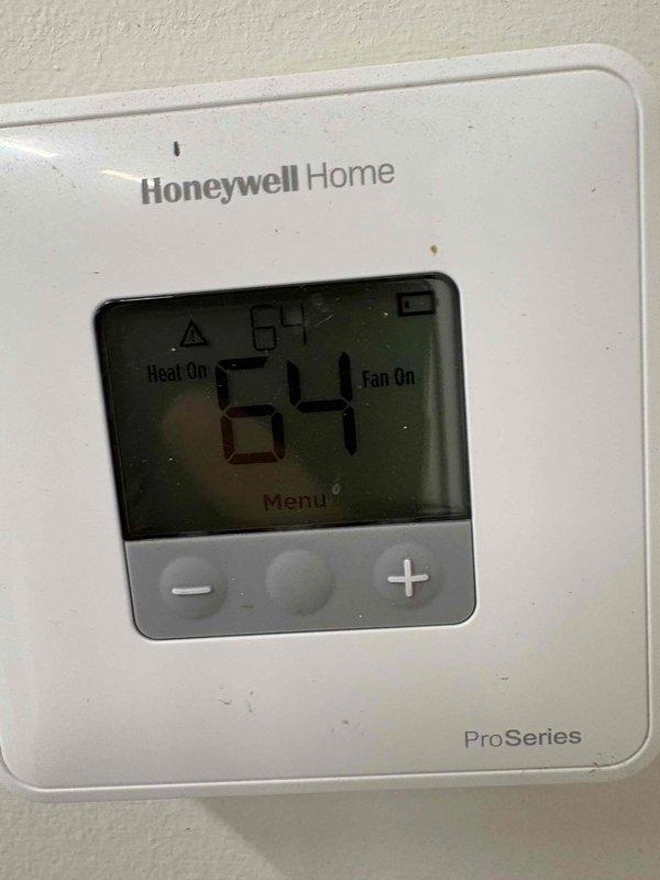 Responded to service call for a 6-year-old Navian boiler that was not producing heat. Upon inspection, found the thermostat was calling for heat (set at 64°F with "Heat On" indicator active), but the boiler was not responding. Diagnosed and replaced a faulty ignition component, restoring proper heating function and confirming system operation before completion.