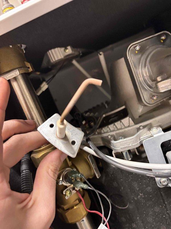 Responded to service call for a 6-year-old Navian boiler that was not producing heat. Upon inspection, found the thermostat was calling for heat (set at 64°F with "Heat On" indicator active), but the boiler was not responding. Diagnosed and replaced a faulty ignition component, restoring proper heating function and confirming system operation before completion.