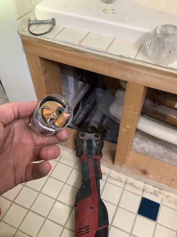 Responded to service call for faucet leak with no separate shut-off valve. Accessed wall cavity to locate main plumbing lines, then used specialized tools to repair the leaking fixture while customer's main water supply remained shut off. Successfully resolved leak issue and restored proper function to bathroom sink faucet.
