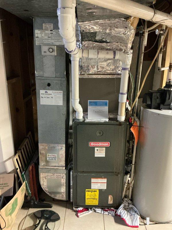 Inspected 18-year-old Goodman furnace with reported leakage issues at exhaust exit and collector box. Visually confirmed condensation leakage from heat exchanger connections, indicating secondary heat exchanger failure. Recommended complete system replacement due to age of equipment and extent of deterioration.